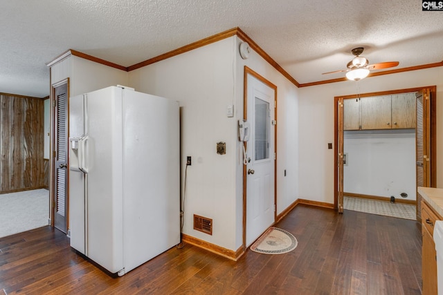 kitchen featuring visible vents, dark wood finished floors, ornamental molding, white fridge with ice dispenser, and a textured ceiling