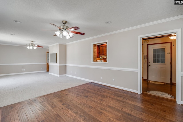 empty room with baseboards, wood finished floors, and crown molding