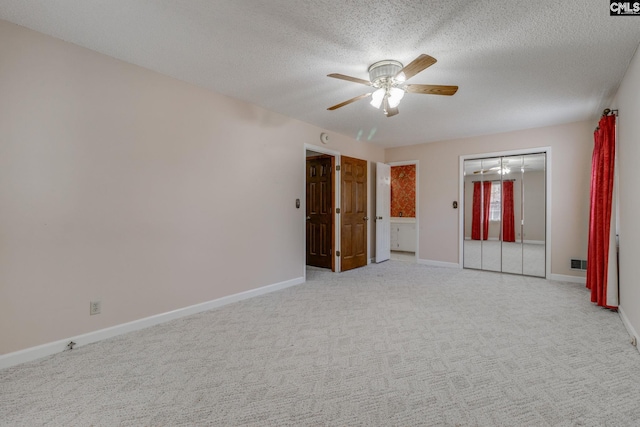 unfurnished bedroom featuring baseboards, light colored carpet, and a textured ceiling