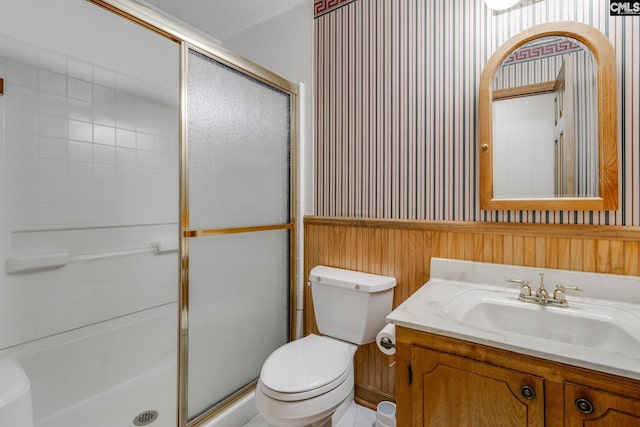 full bath featuring a shower with shower door, toilet, and vanity