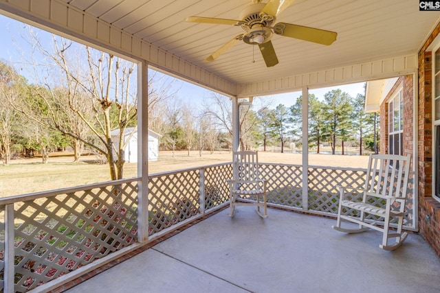 view of patio / terrace with ceiling fan, a storage shed, and an outdoor structure