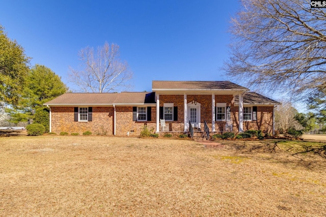 view of front facade featuring brick siding, crawl space, and a porch