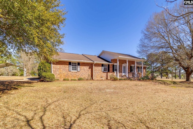 view of front of property with brick siding, a porch, and a front lawn