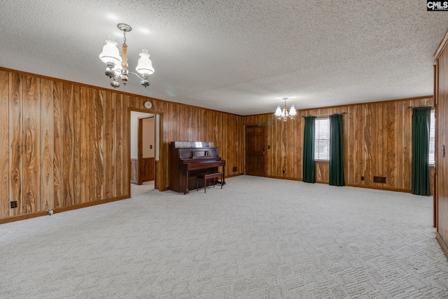 interior space featuring a textured ceiling, a notable chandelier, and light carpet