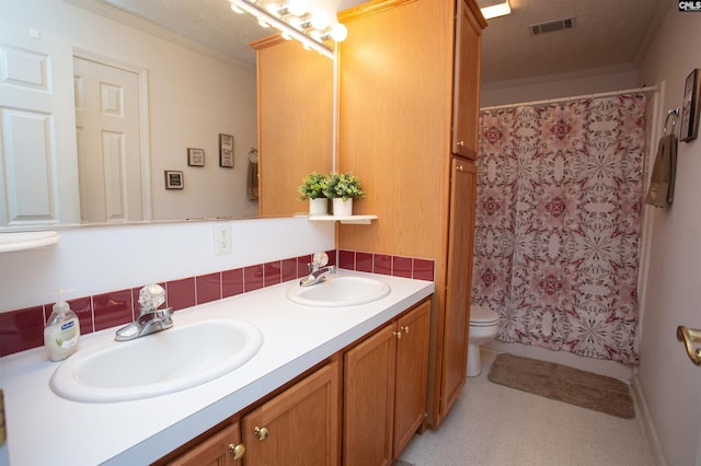 full bath featuring crown molding, double vanity, visible vents, and a sink