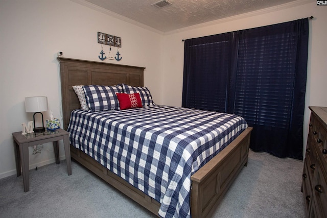 bedroom with a textured ceiling, crown molding, visible vents, and light carpet