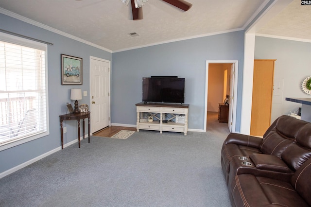 carpeted living room with visible vents, baseboards, crown molding, and a ceiling fan