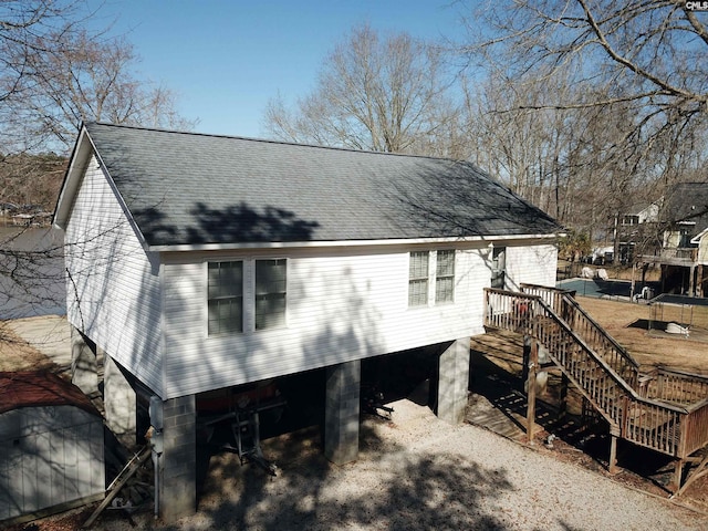 back of property featuring roof with shingles