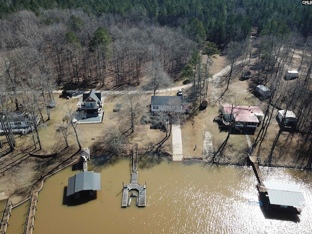 drone / aerial view with a forest view and a water view