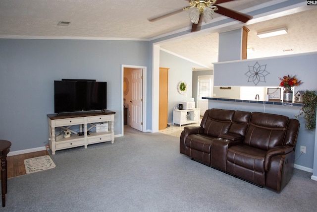 living room featuring a textured ceiling, crown molding, a ceiling fan, and vaulted ceiling