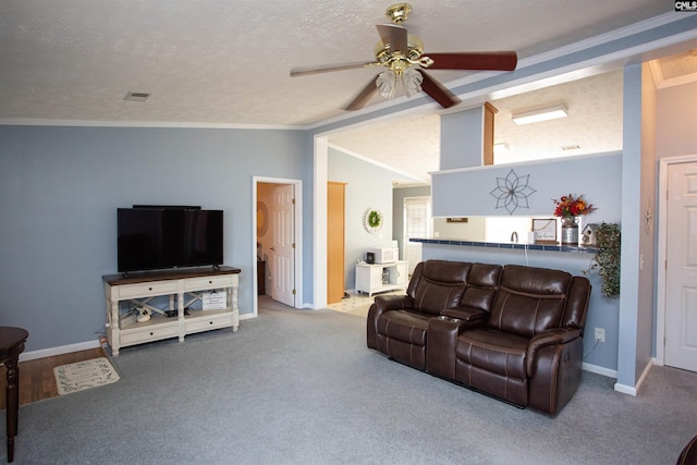 living area featuring visible vents, ornamental molding, a ceiling fan, a textured ceiling, and vaulted ceiling