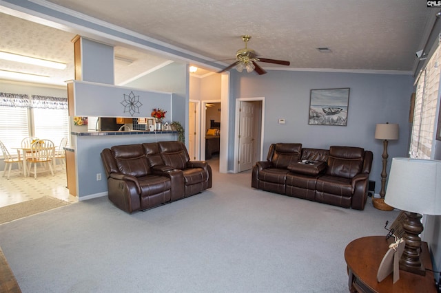 carpeted living room with a ceiling fan, visible vents, ornamental molding, vaulted ceiling, and a textured ceiling