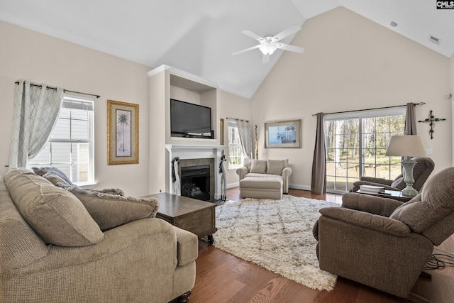 living room with visible vents, high vaulted ceiling, dark wood finished floors, a fireplace with flush hearth, and ceiling fan