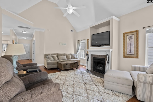 living room featuring wood finished floors, baseboards, visible vents, high vaulted ceiling, and a tile fireplace