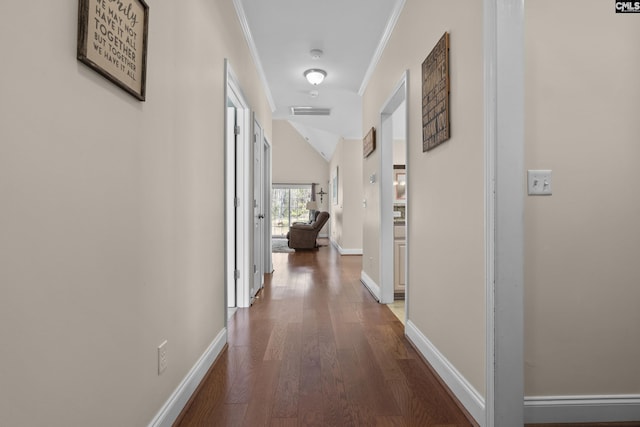 corridor with wood finished floors, visible vents, baseboards, vaulted ceiling, and crown molding