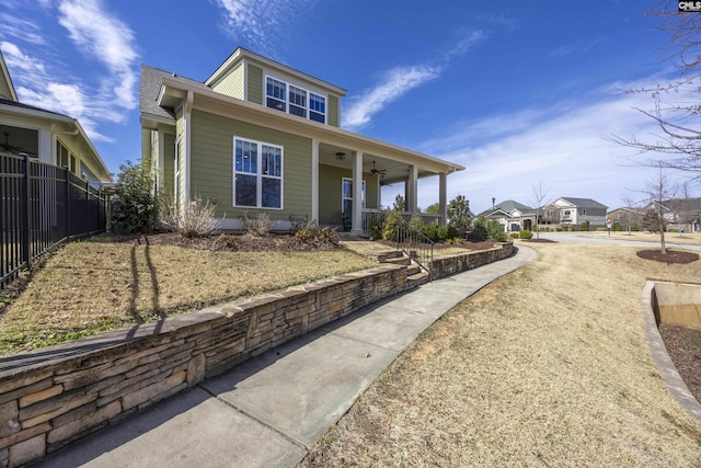 view of front of home featuring covered porch, ceiling fan, and fence