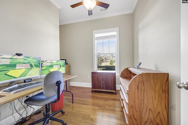 home office with ceiling fan, crown molding, baseboards, and wood finished floors