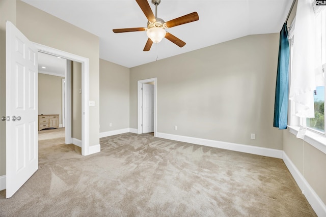 unfurnished bedroom featuring lofted ceiling, carpet flooring, a ceiling fan, and baseboards