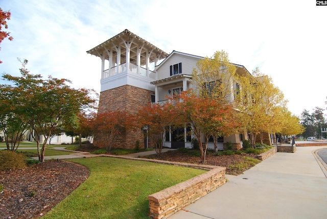 view of property exterior featuring a yard and a balcony