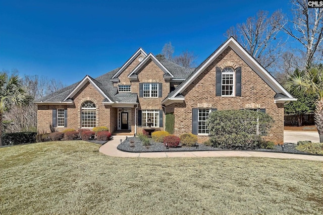 traditional home featuring brick siding and a front lawn