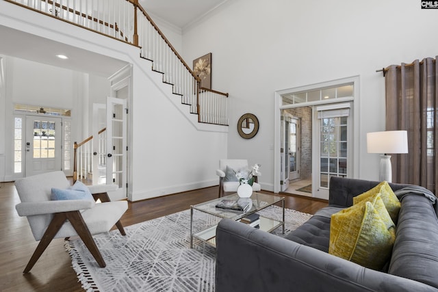 living area featuring stairs, a high ceiling, and wood finished floors