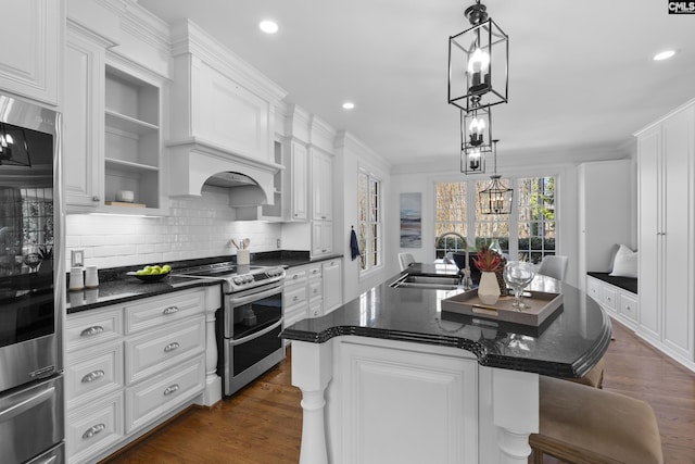 kitchen with a sink, dark wood-type flooring, appliances with stainless steel finishes, and white cabinets