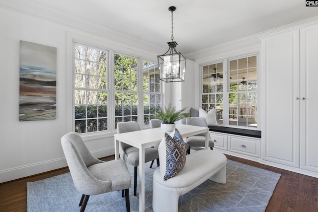 dining area featuring crown molding, baseboards, dark wood-style flooring, and a chandelier