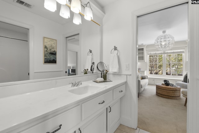 bathroom with visible vents, an inviting chandelier, vanity, and tile patterned flooring