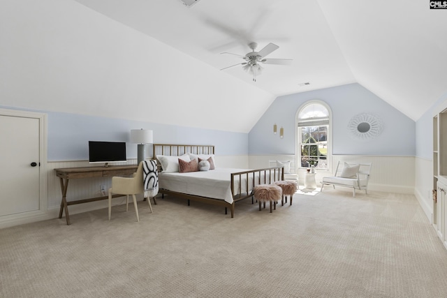 bedroom featuring a wainscoted wall, lofted ceiling, and light colored carpet