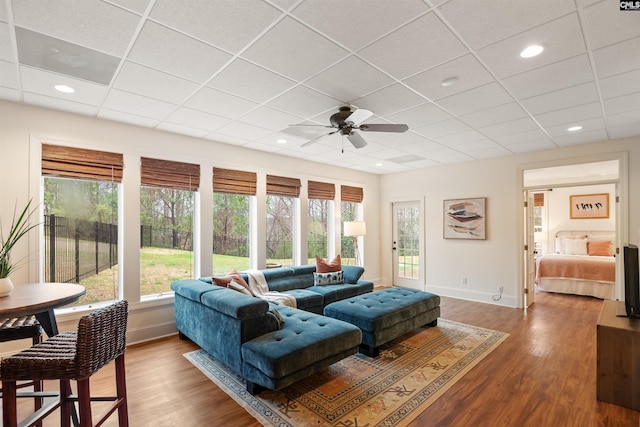 living area with plenty of natural light, baseboards, and wood finished floors