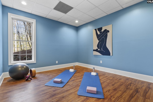 workout room featuring recessed lighting, a drop ceiling, baseboards, and wood finished floors