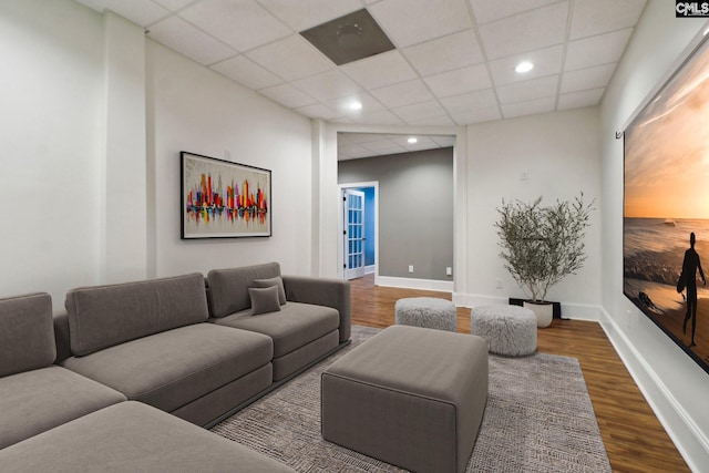 living room featuring recessed lighting, wood finished floors, baseboards, and a paneled ceiling