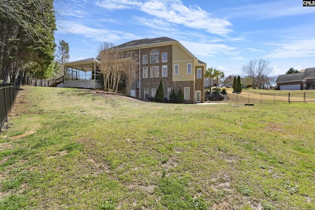 rear view of house featuring brick siding, a lawn, and a fenced backyard