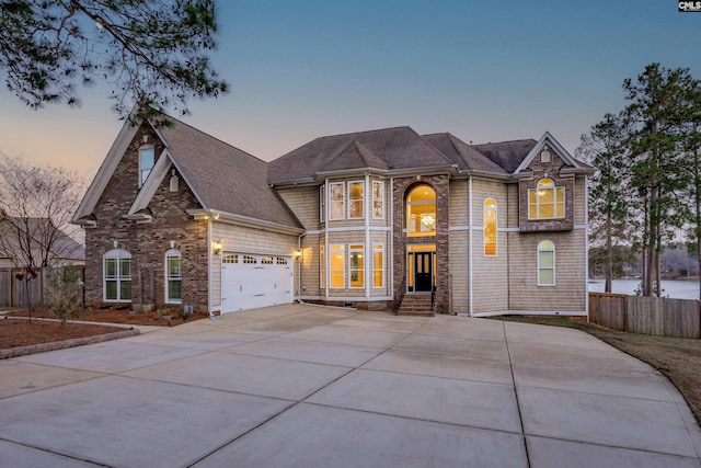 view of front facade with an attached garage, fence, and driveway