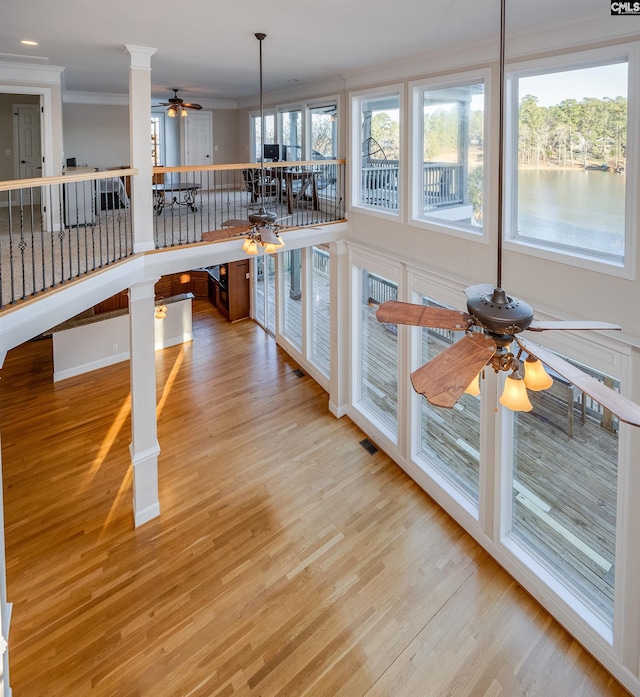 kitchen with a wealth of natural light, wood finished floors, and crown molding