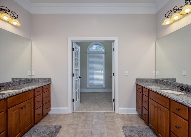 full bathroom featuring ornamental molding, two vanities, and a sink