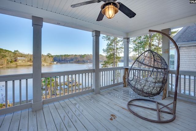 wooden terrace featuring ceiling fan and a water view