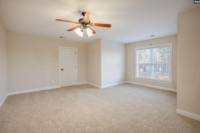 unfurnished room featuring ceiling fan, baseboards, visible vents, and light carpet