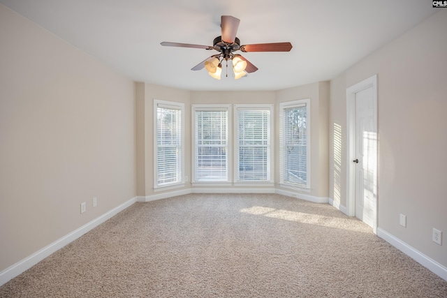 carpeted spare room with baseboards and ceiling fan