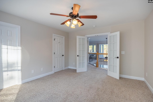 empty room with carpet, french doors, baseboards, and ceiling fan