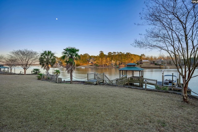 dock area with a gazebo, a lawn, and a water view