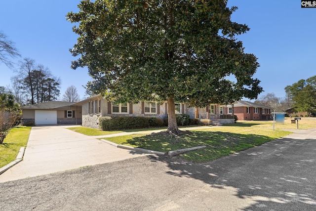 view of property hidden behind natural elements featuring a garage, concrete driveway, a front lawn, and stone siding