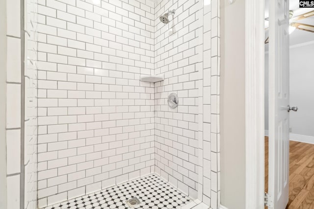 full bathroom featuring wood finished floors, a stall shower, and ornamental molding