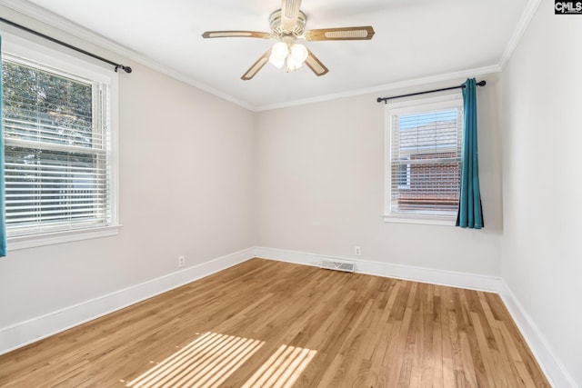 spare room with light wood-type flooring, baseboards, ceiling fan, and crown molding