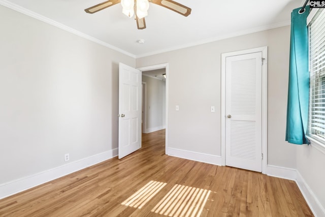 unfurnished bedroom featuring baseboards, ornamental molding, and light wood finished floors