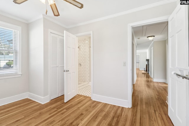 unfurnished bedroom featuring light wood-type flooring, baseboards, attic access, and crown molding