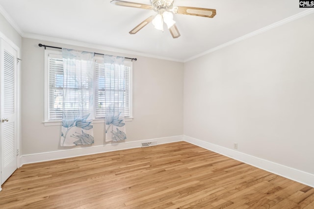 spare room with crown molding, light wood-style flooring, baseboards, and ceiling fan