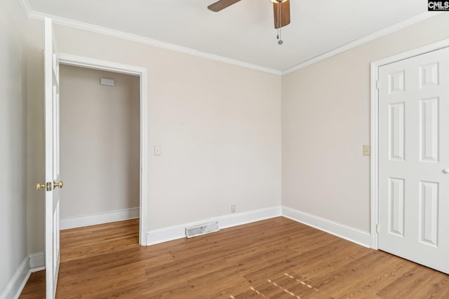 spare room with ornamental molding, a ceiling fan, and wood finished floors