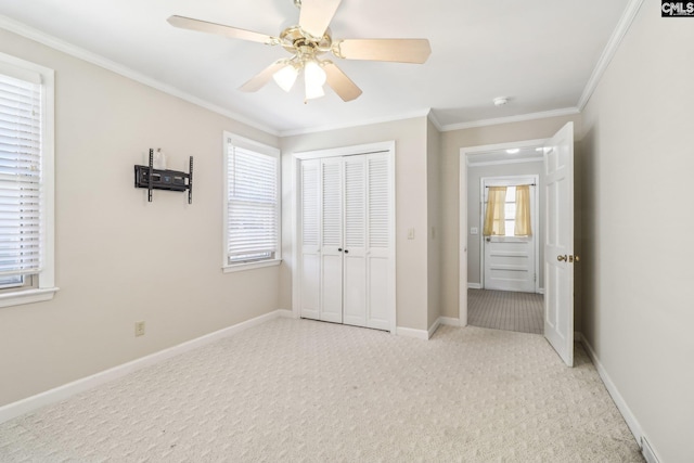 unfurnished bedroom with baseboards, carpet floors, a closet, and crown molding