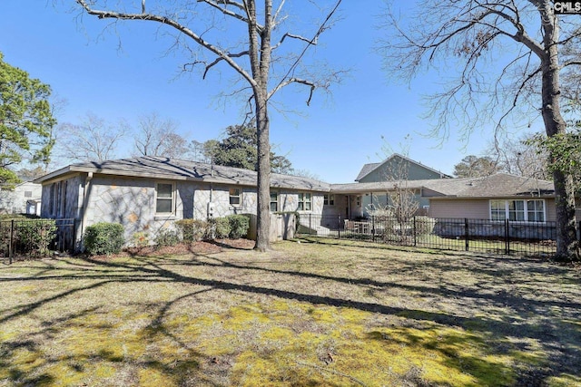 rear view of property with a yard and fence